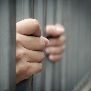 a person holding the jail bars